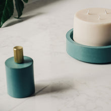 Load image into Gallery viewer, concrete and wax lifestyle shot with candle snuffer and teal concrete candle plate
